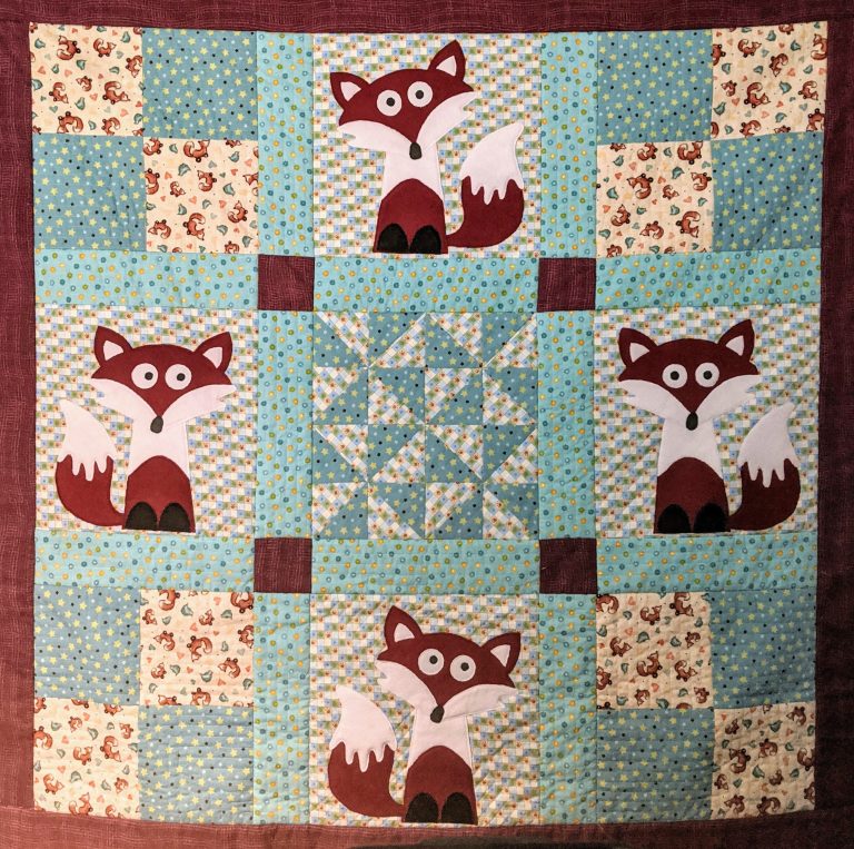 Handsewn quilt by Rebecca Holmlund.  Panels have cartoon-like foxes on them.