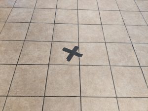 View larger photo: Black tape making an X on the floor to help with social distancing