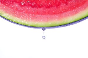 Drop of water falling from the skin of a watermelon