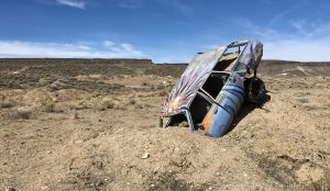 Abandoned Spray Painted Car Buried In The Desert