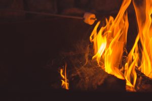 A single marshmallow roasting over a crackling campfire.