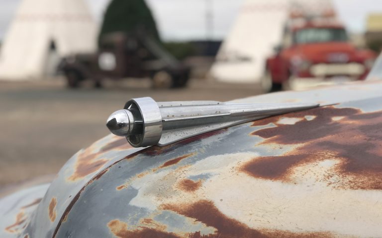 Vintage hood ornament on a rusty car