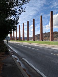 Old smoke stacks, without a factory, next to a road on a sunny day