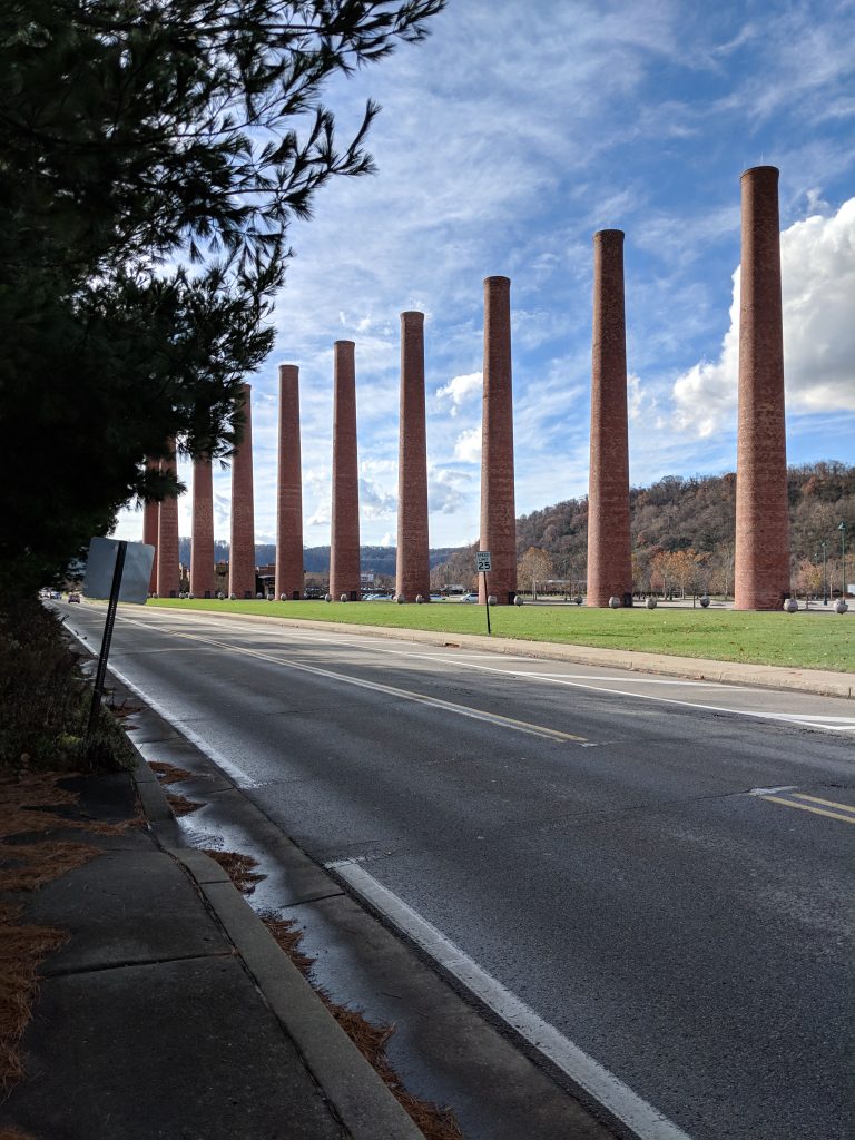 Old smoke stacks, without a factory, next to a road on a sunny day