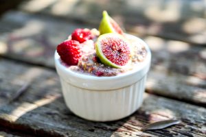 A bowl of overnight oats topped with fig and raspberries