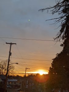 The sun rising at the bottom of a residential street