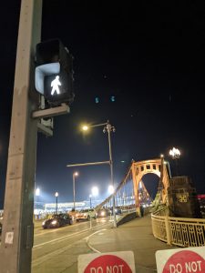 The beginning of Pittsburgh's Roberto Clemente bridge at night, with a wall sign