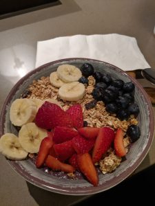 A bowl of oatmeal with bananas and strawberries on top