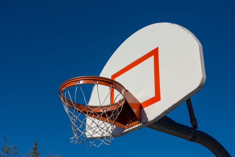 Outdoor basketball hoop against a blue sky