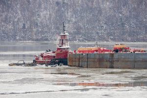 Tugboat and barge on the icy Hudson River
