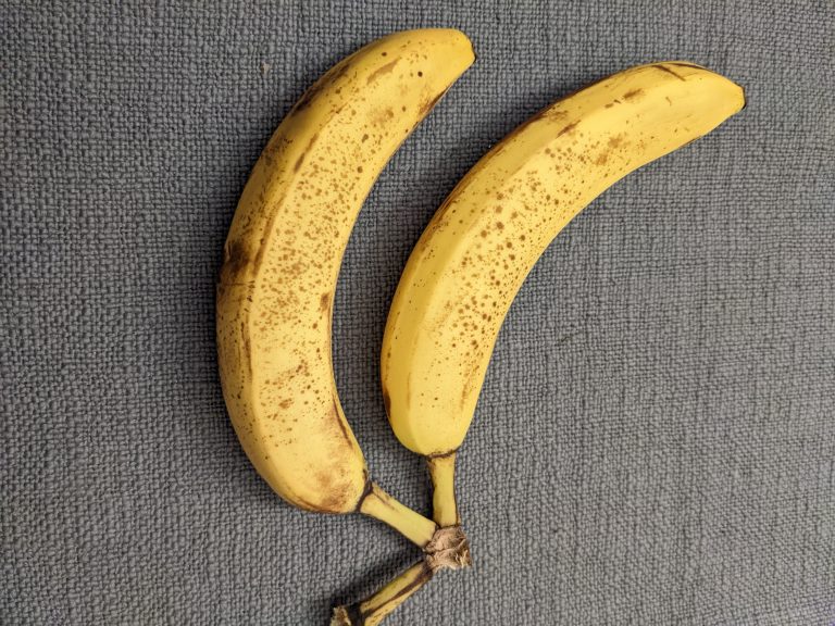 Two older bananas on a gray cloth