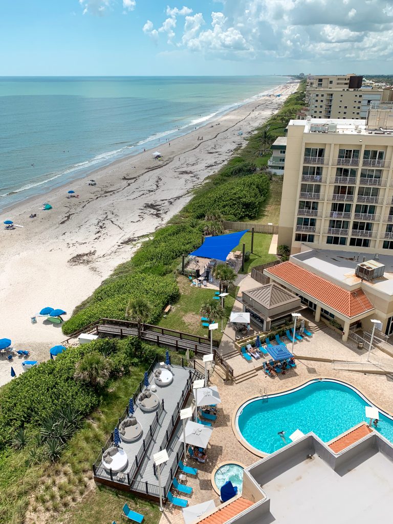 View of the beach from the top floor of a hotel balcony