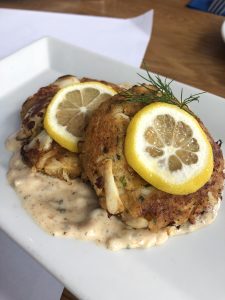 Two crab cakes with lemon slices on top