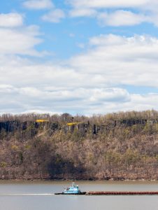 Blue tugboat with barge on the Hudson River in spring