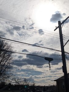 The sky, with clouds and a telephone pole in front