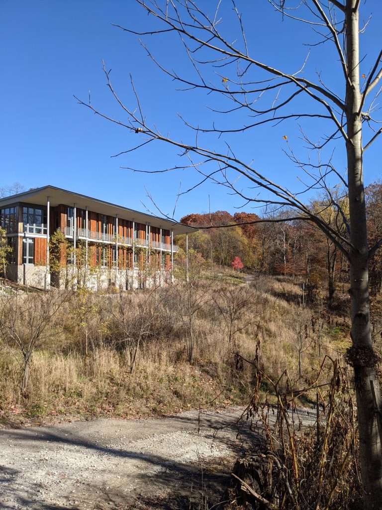 Frick Park Nature Center pictured from below and surrounded by trees.