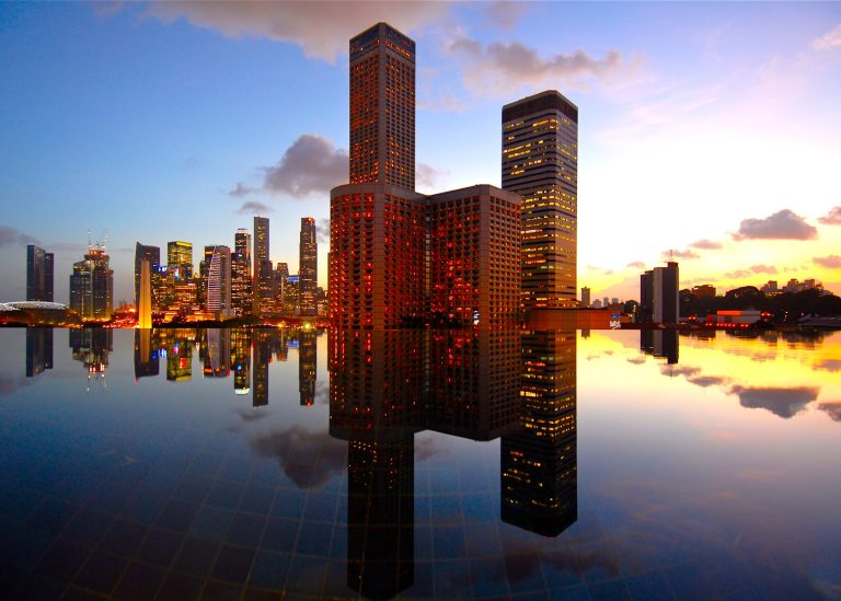 Singapore skyline at sunset across an infinity pool