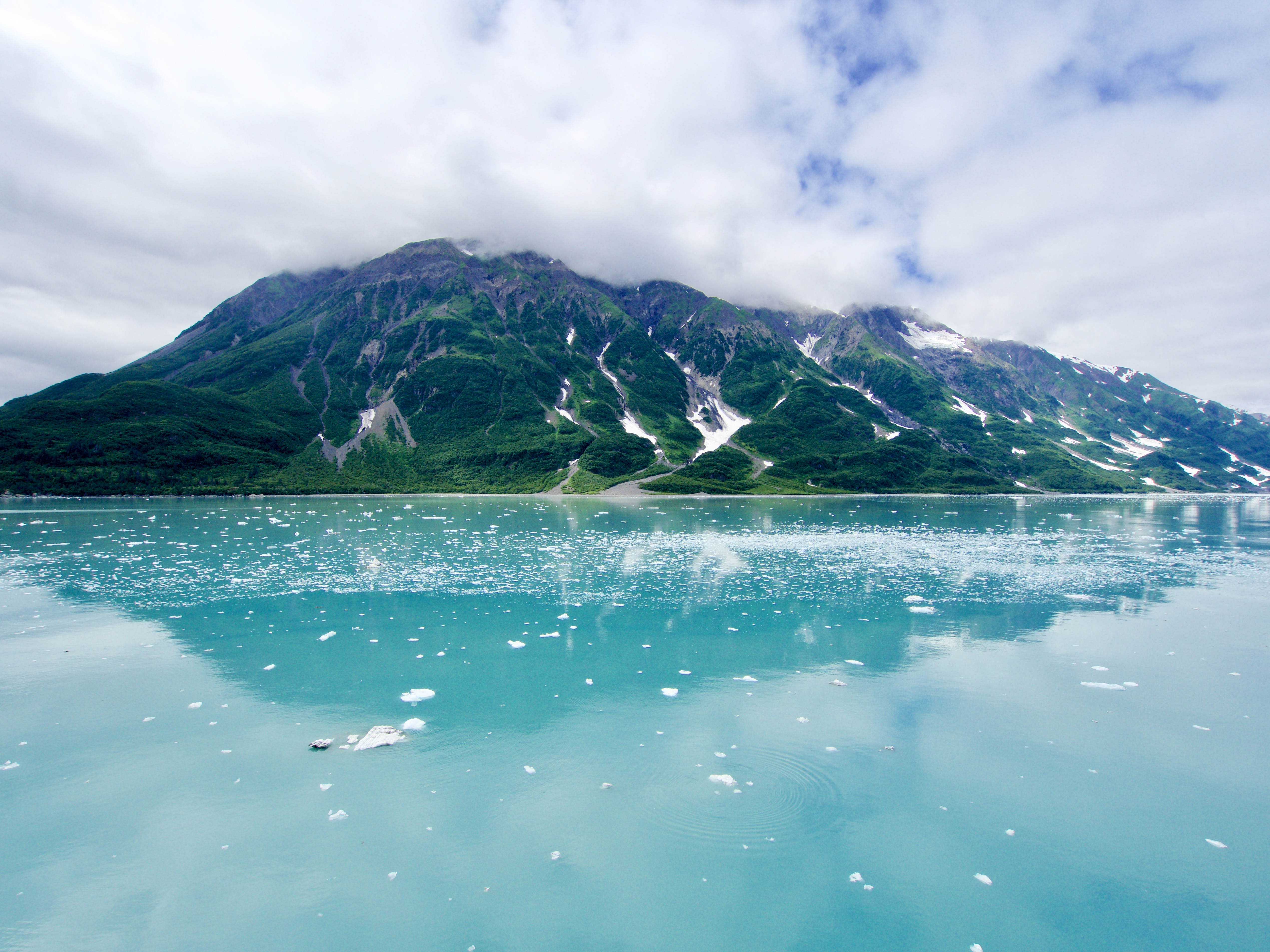 Alaskan landscape showing rainforest hills and glacial waters.