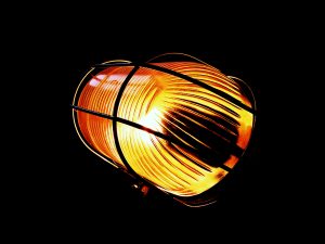 Bulkhead light with incandescent bulb against black background