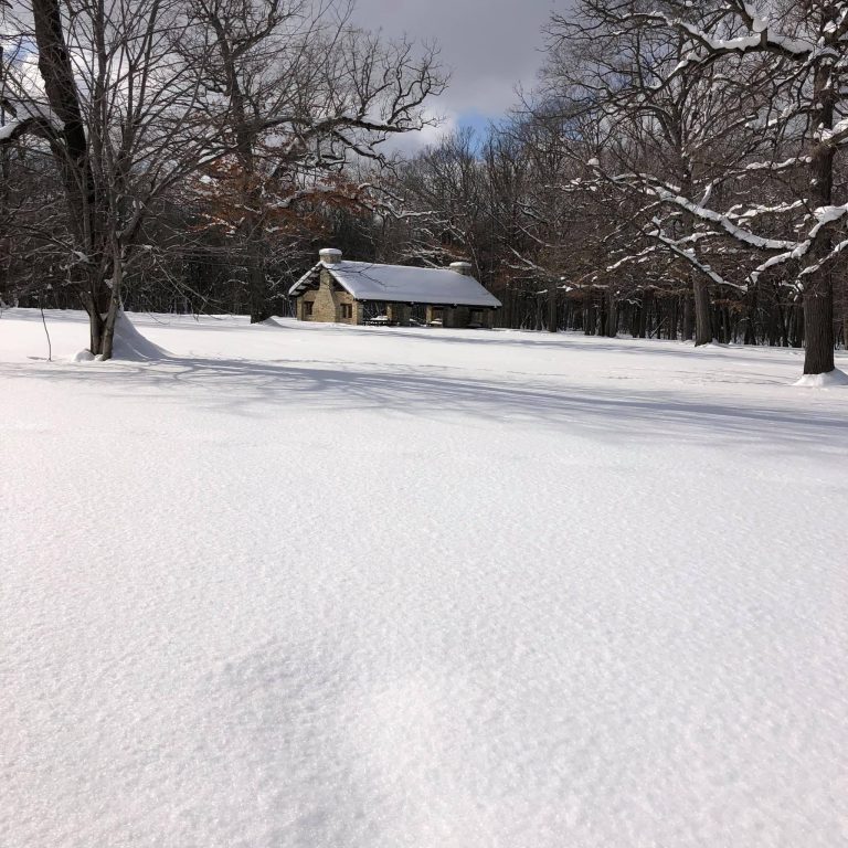 Stone pavilion in a park covered in snow