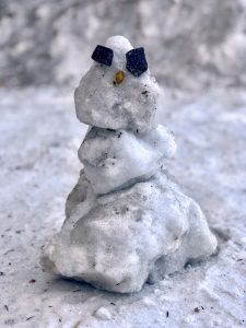 Tiny snowman made of chunks of ice and rocks