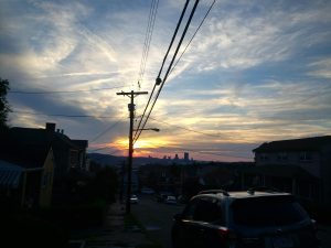 Sunset over downtown Pittsburgh, PA. See at a distance with slot of residential area in the foreground