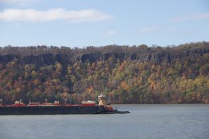 Barge and tugboat on the Hudson River with the Palisades in the background in autumn
