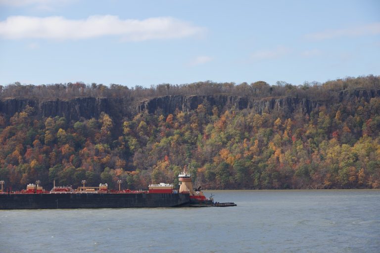 Barge and tugboat on the Hudson River with the Palisades in the background in autumn