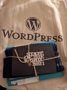 A tote bag and hat with WordPress logos on them