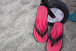 Pink and black sandals at the beach