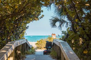 View larger photo: Scooter at the end of a boardwalk covered in sea oats leading to the beach