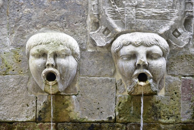 Sculpture, human heads in a fountain pouring water through the mouth in Avilés (Spain)