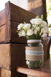 Bouquet of white roses in a glass jar (wedding table decor)