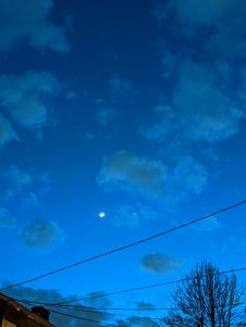 The moon, in a dark, but not totally dark sky