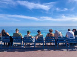 Group of people chilling out in front of the Mediterranean sea in Nice, France
