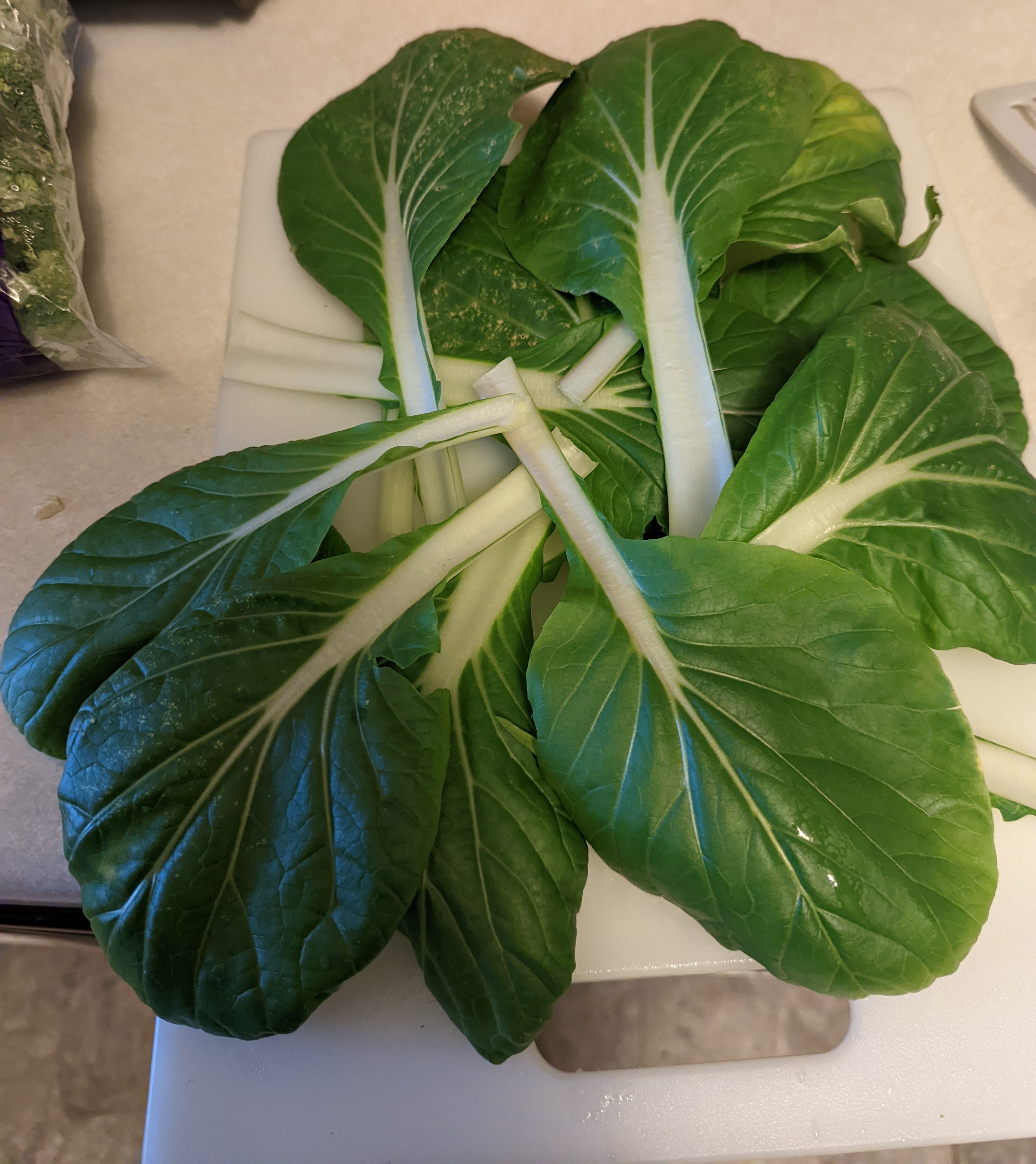 A bunch of Bok Choy on a cutting board, ready to get chopped.