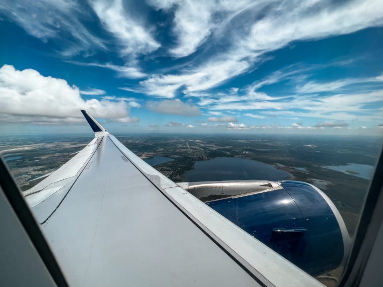 View of the wing and ground from the window of an airplane