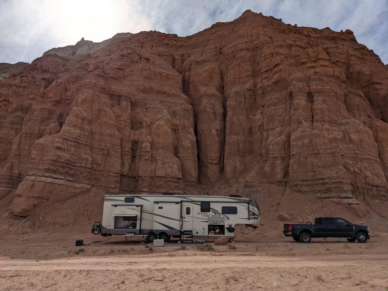 Boondocking camper in desert. Black truck and fifth wheel campsite at Goblin Valley State Park.