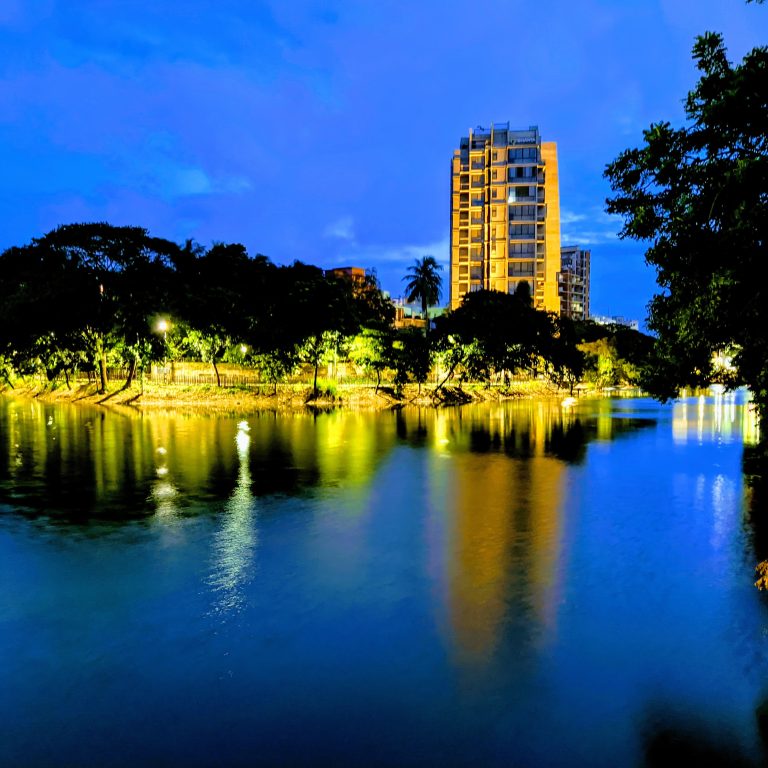 An upside down building with city lights surrounded by lake in the middle of the capital