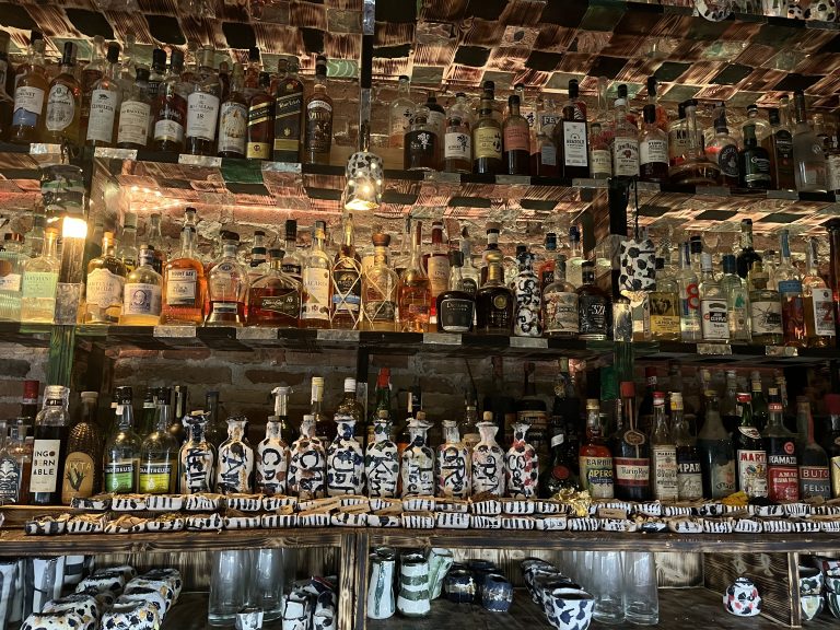 Liquor shelves with dozen of hand moulded spice bowls at the bottom