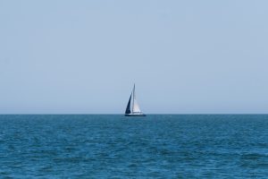 A sailboat in the distance on the horizon in the Atlantic Ocean
