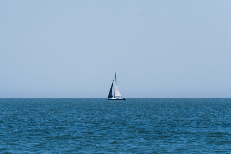 A sailboat in the distance on the horizon in the Atlantic Ocean