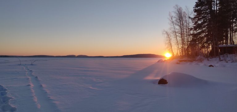 Sunset and snow over frozen lake view