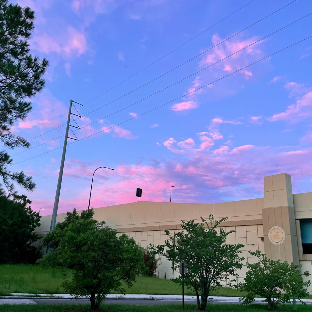 The morning sky over a highway overpass in Orlando, Florida. The clouds are a mix of pinks and purples in front of a blue sky. WorldPhotographyDay22