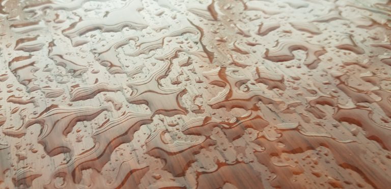 Rain water drops on wood table.