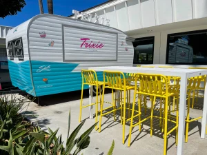 Camping trailer styled food truck with tables and seating