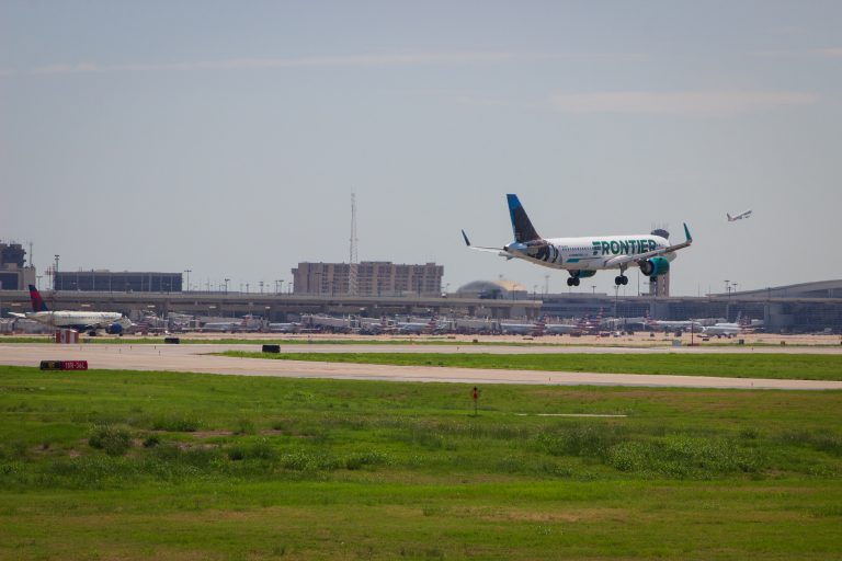 A Frontier Airlines plane lands while a Delta Airlines plane takes off