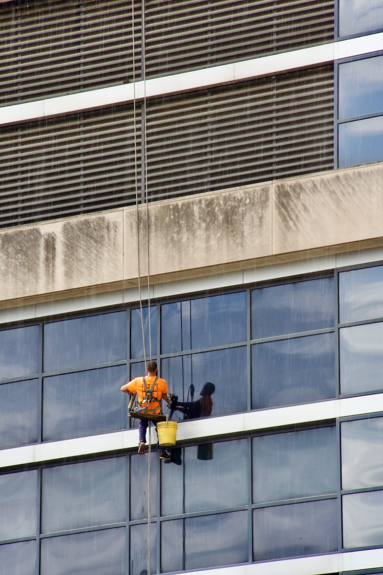 A window washer working in the rain