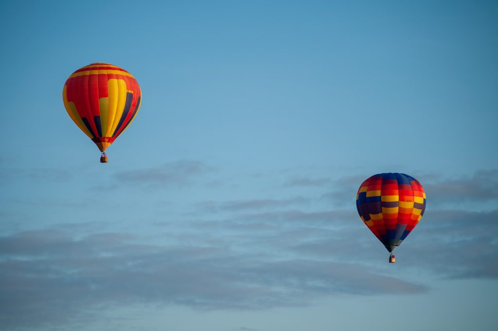 Two colourful hot air balloons fly in the clear blue Ottawa skies