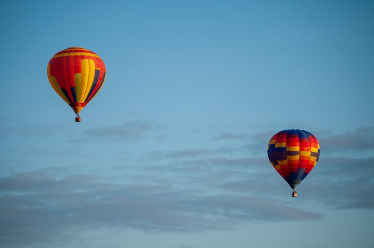 Two colourful hot air balloons fly in the clear blue Ottawa skies